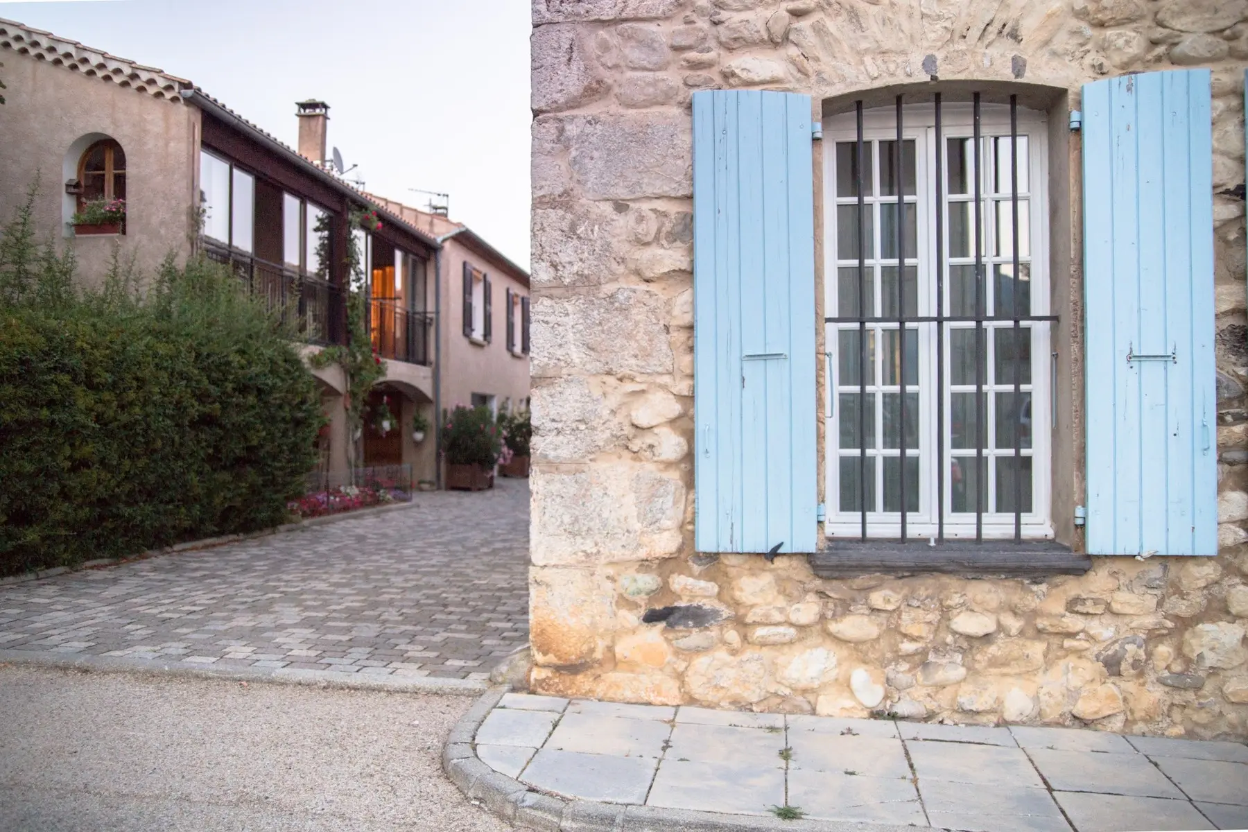 Rue d’un village de pierre calcaire du Périgord, volets bois et encadrements en pierre de taille